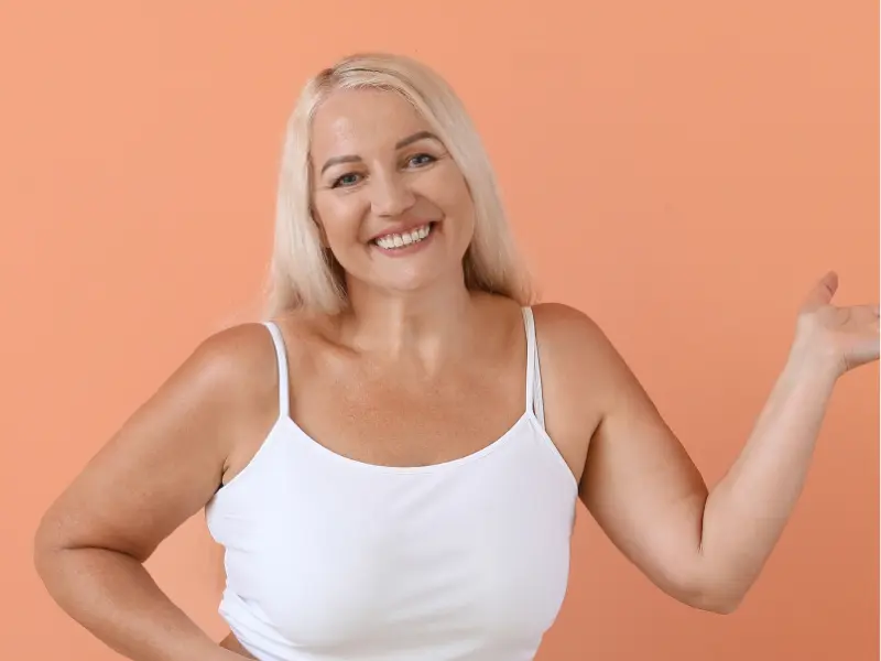Article about: "Is Your Self Esteem Low?" Image shows a smiling woman that looks confidently at the camera, challenging the idea of 'low self esteem' and celebrating self-acceptance.